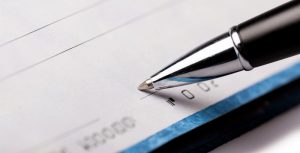 Søknadsprosessen for refinansiering avhenger av hvilken type gjeld du planlegger å refinansiere. Illustrasjonsbilde av sjekk og signatur